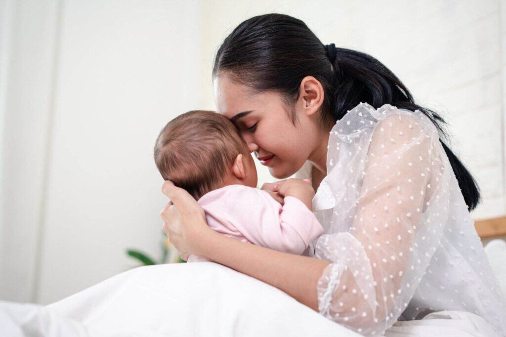 Mutter hält neugeborenes Baby, emotionale Verbindung, Unterstützung bei Geburt.