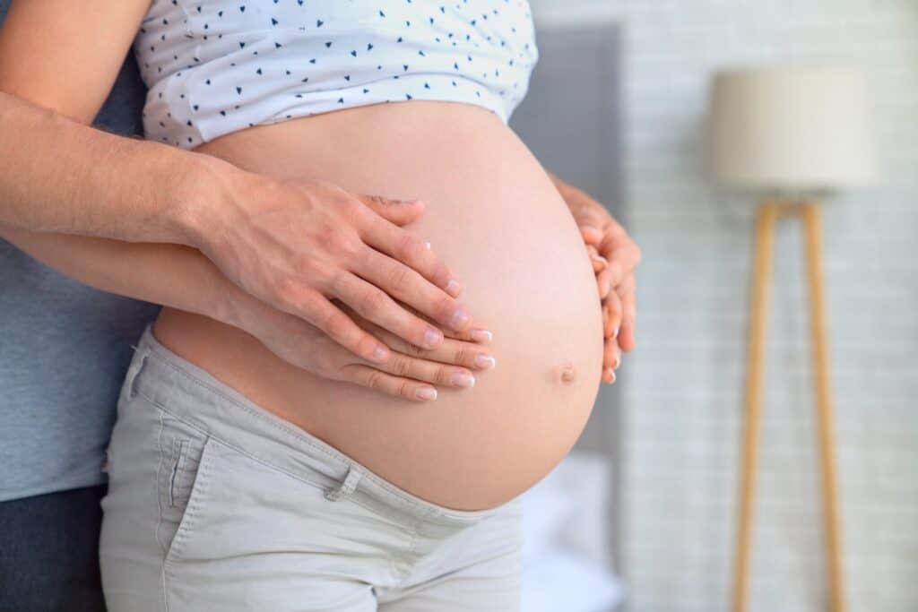 Schwangerschaftsbauch mit Partner, Unterstützung bei Geburtsvorbereitung, Geburtshelfer-App für werd.