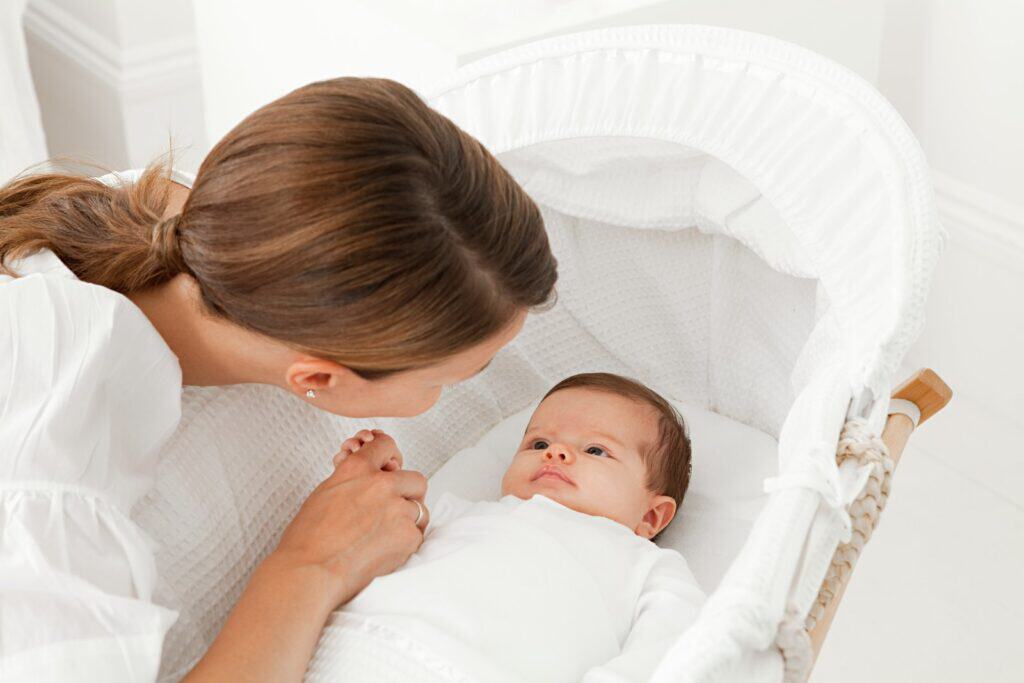 Mutter hält Baby im Bett, liebevolle Verbindung, Geburtshelden.